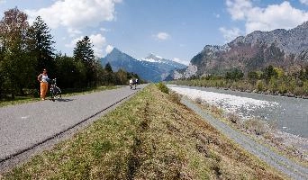 Bank and path by the Rhine river on the Liechtenstein border, outdoors, person, rural, woman, mountains, flow, alps, water, valley, bed, river, rocks, rhine, daylight, liechtenstein, sunshine, switzerland, hiking, europe, walking